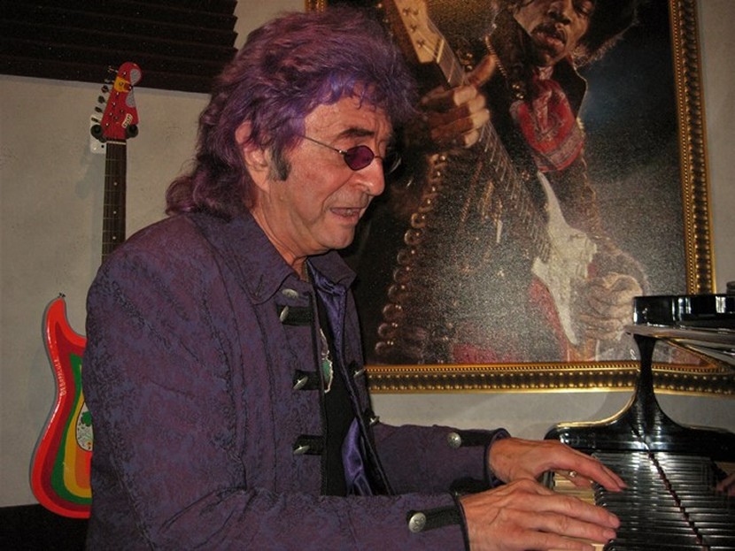 Jim Peterik plays grand piano in his studio